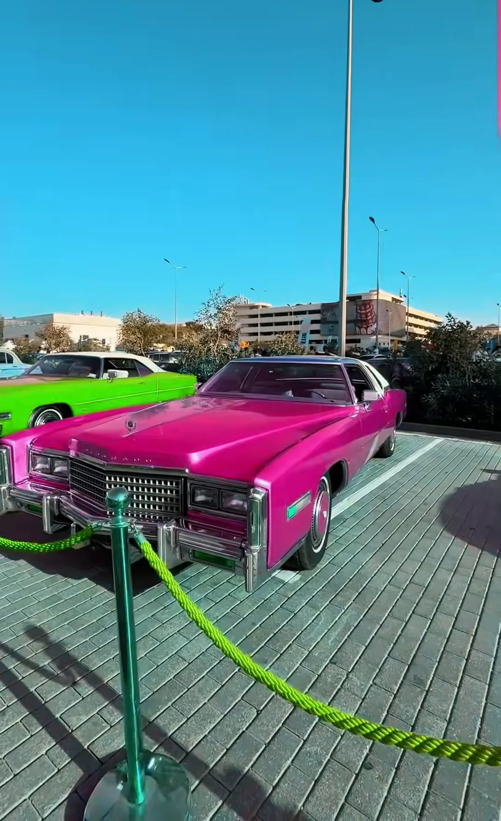 Розовый Cadillac Eldorado за ограждением выставки